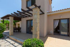 a patio with a wooden pergola on a house at Seaview Villa Mia in Lachi