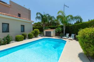a swimming pool in front of a house at Seaview Villa Mia in Lachi