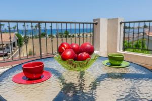 a bowl of apples on a table with two cups at Seaview Villa Mia in Lachi