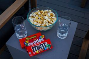 a table with a bowl of popcorn and glasses of water at Luxury Condo - The Gulch - Private Rooftop in Nashville +29 photos