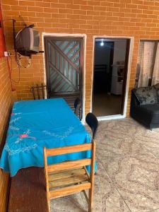 Zimmer mit einem Tisch, einem Stuhl und einer Tür in der Unterkunft Lar do Litoral - Praia Grande in Praia Grande
