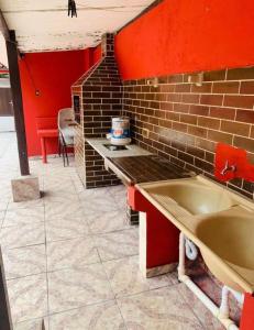 eine Küche mit Spüle und Ziegelwand in der Unterkunft Lar do Litoral - Praia Grande in Praia Grande