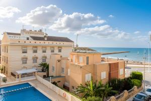 ein Gebäude mit einem Pool am Meer in der Unterkunft Mar 4 en Santa Pola in Santa Pola