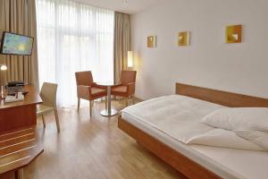 a bedroom with a bed and a table and chairs at Hotel Arte Spreitenbach in Spreitenbach