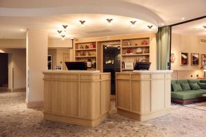 a lobby with a reception desk and a green couch at Sorell Boutique-Hotel Speer Rapperswil in Rapperswil-Jona