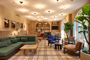 a living room with a green couch and chairs at Sorell Boutique-Hotel Speer Rapperswil in Rapperswil-Jona