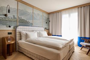 a bedroom with a large bed with a painting on the wall at Sorell Boutique-Hotel Speer Rapperswil in Rapperswil-Jona +20 photos
