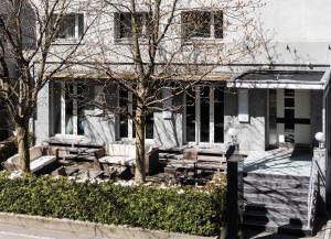 a house with benches and a tree in front of it at Self Check-In Hotel David 22 in St. Gallen