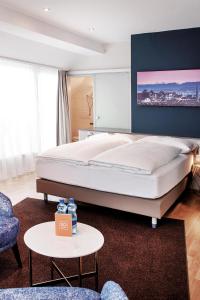 a bedroom with a large white bed and a table at Sorell Hotel Rex Zürich in Zürich