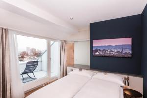 a hotel room with a bed and a window at Sorell Hotel Rex Zürich in Zürich