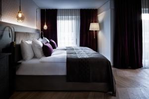 a bedroom with a large bed with pillows at Sorell Boutique-Hotel Seefeld Zürich in Zurich