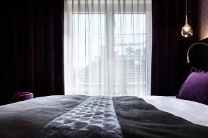 a bedroom with a bed and a large window at Sorell Boutique-Hotel Seefeld Zürich in Zürich