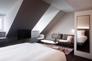 um quarto com uma cama grande e um sofá em Sorell Boutique-Hotel Zürichberg em Zurique