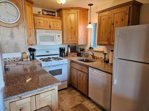 eine Küche mit weißen Geräten und Holzschränken in der Unterkunft Heavenly Stagecoach Ski Retreat in Summit Village