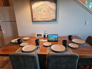 einem Holztisch mit Tellern und Utensilien darauf in der Unterkunft Heavenly Stagecoach Ski Retreat in Summit Village