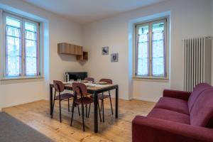 ein Wohnzimmer mit einem Tisch und einem lila Sofa in der Unterkunft Apartments and holidays Cav Paolo Tione di Trento in Tione di Trento