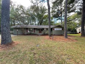 ein Haus in einem Hof mit Bäumen davor in der Unterkunft Roomy 4BR Home with Fenced Yard in Jackson