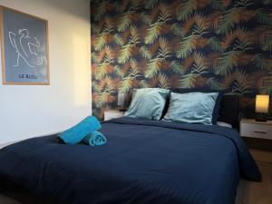 a bedroom with a blue bed with a wall at Trois pièces vue campagne à Bâlines in Balines