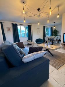 a living room with a blue couch and a table at Trois pièces vue campagne à Bâlines in Balines