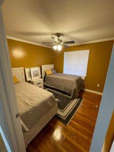 ein Schlafzimmer mit zwei Betten und einem Deckenventilator in der Unterkunft Roomy 4BR Home with Fenced Yard in Jackson