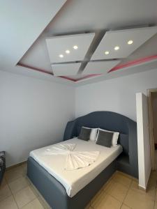 un dormitorio con una cama con cabecero azul en Golden Flower Hotel, en Tirana 12 fotos más