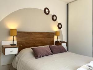 ein Schlafzimmer mit einem großen Bett mit zwei Nachttischen und zwei Lampen in der Unterkunft CASA RUBÍ - ENCANTADOR APARTAMENTO EN MENDOZA - Cochera Privada y Seguridad Permanente in Guaymallen