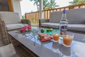 a bottle of orange juice and two glasses on a table at L'Escapade Créole in Saint-François