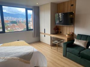 a bedroom with a bed and a couch and a television at Hotel Ryo 74b Piso 7 Vip in Medellín