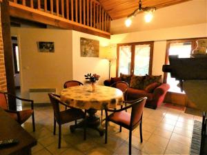 a living room with a table with chairs and a couch at Notre bergerie in Soustons