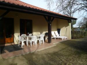 a patio with a table and chairs on a house at Notre bergerie in Soustons