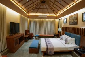 une chambre d'hôtel avec un lit et une télévision dans l'établissement Wild Forest, à Sasan Gir