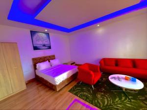 a bedroom with a bed and a red couch at AS Appartement meublé in Bamako