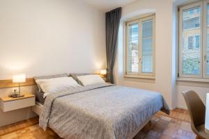 ein Schlafzimmer mit einem Bett und zwei Fenstern in der Unterkunft Apartments and holidays Cav Paolo Tione di Trento in Tione di Trento