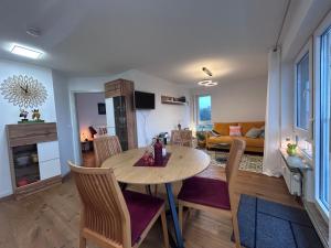 ein Esszimmer und ein Wohnzimmer mit Tisch und Stühlen in der Unterkunft Ferienwohnung Karma in Kressbronn am Bodensee