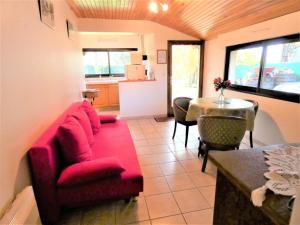 a living room with a red couch and a table at L'ecureuil in Soustons