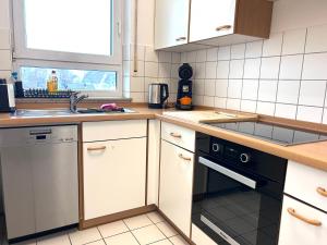 eine Küche mit Spüle und Geschirrspüler in der Unterkunft Ferienwohnung Karma in Kressbronn am Bodensee + 3 Fotos