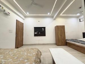 une chambre avec deux lits et une télévision au mur dans l'établissement Hotel Devi Heritage - Near Prem Mandir, à Vrindavan 17 autres photos