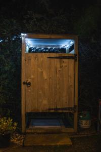 a wooden door with lights on it at night at Shepherds hut in Kent