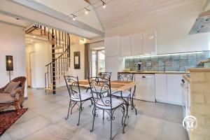 una cucina e una sala da pranzo con tavolo e sedie di Jardin de l'ardoiserie a Saint-Gravé