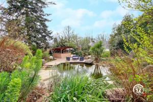 un giardino con laghetto e gazebo di Jardin de l'ardoiserie a Saint-Gravé Altre 19 foto