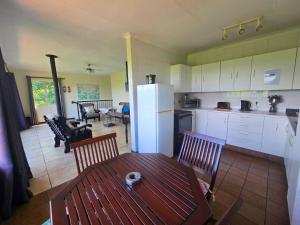 a kitchen with a table and chairs and a refrigerator at Hills and Dales Accommodation in Lanseria