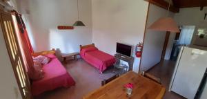 a living room with two beds and a table at Las Rosas EH in El Hoyo