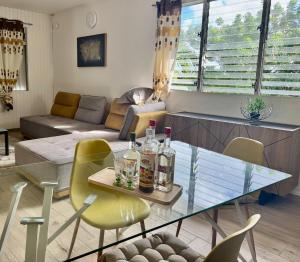 a living room with a glass table and chairs at Villa Valey, spacious and authentic in Le Lamentin