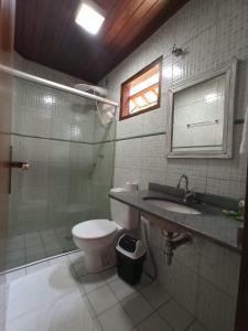 um banheiro com vaso sanitário, chuveiro e pia em Pousada Canto do Sabiá - Pirenópolis em Pirenópolis