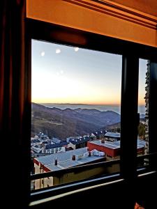 una vista de una ciudad desde una ventana en Monte Oiz junto a telesilla ERB Alojamientos, en Sierra Nevada