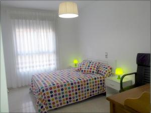 a bedroom with a bed with a polka dot blanket at Acogedor apartamento en el Casco Historico in Jávea