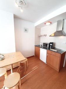 Una cocina con una mesa de madera y una mesa y sillas. en Monte Oiz junto a telesilla ERB Alojamientos, en Sierra Nevada 3 fotos más