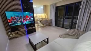 a living room with a flat screen tv on a wall at Beachfront Premium Apartment with Sunset, Pools & Sea View in Portimão