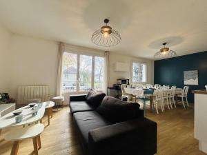 a living room with a couch and tables and chairs at Casa Grand Groupe in Sorges
