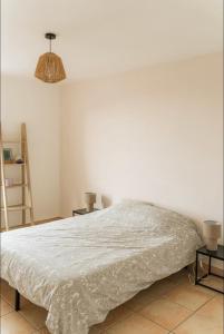 ein Bett in einem Zimmer mit einer weißen Wand in der Unterkunft Grand appartement 2 chambres avec wifi in Perpignan
